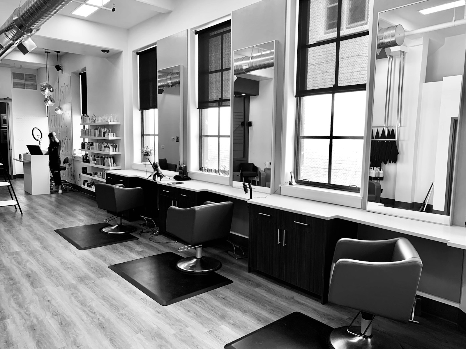 Stylist finishing a client's hair at a salon station